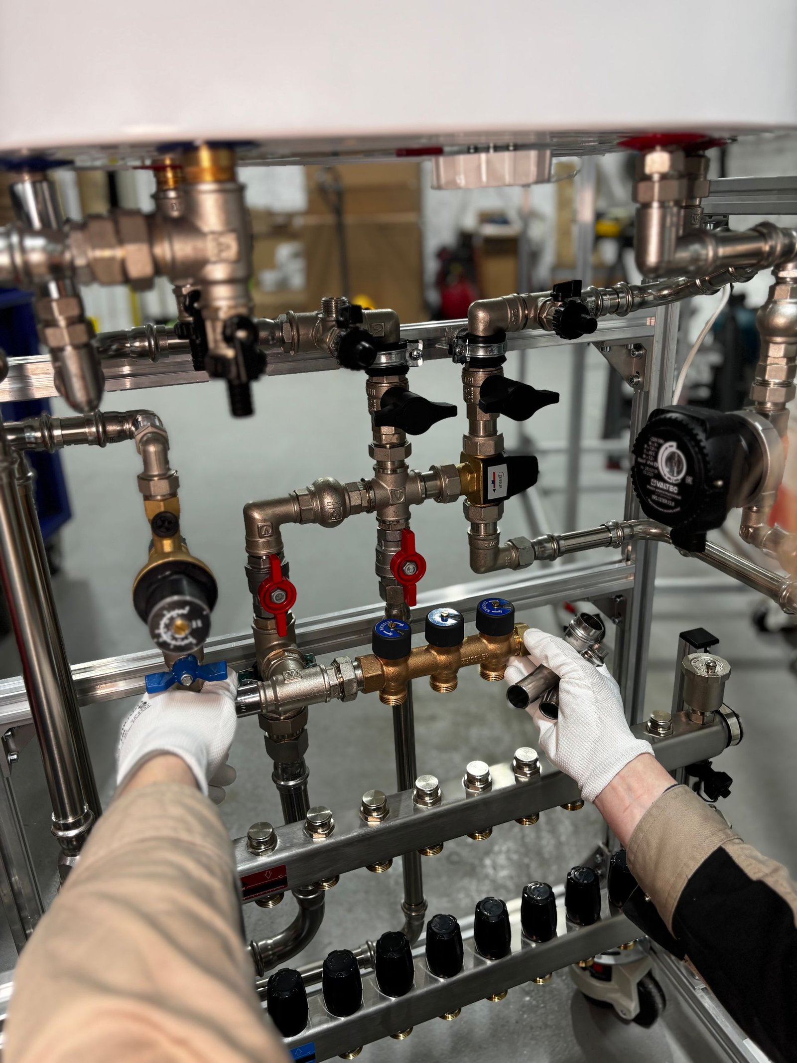 Engineer adjusting metal pipeline valves in an industrial setting with precision.