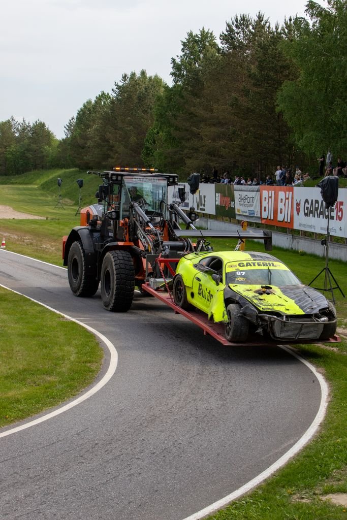 Front-end damaged car being towed on a racetrack in Norway.
